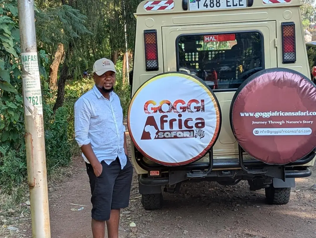 The founder of Goggi Africa Safari beside one of the company's safari vehicles