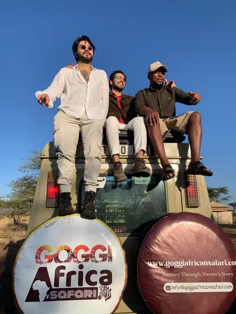 Guests and their Goggi guide on the roof of the safari vehicle