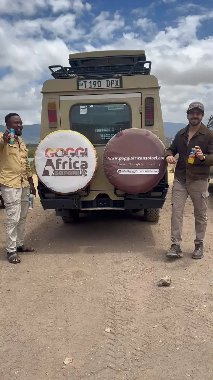 Goggi team and guest behind a branded Goggi safari vehicle