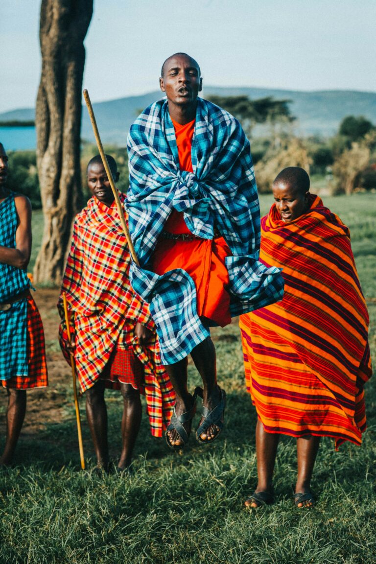 Maasai woman in red and blue with a walking stick